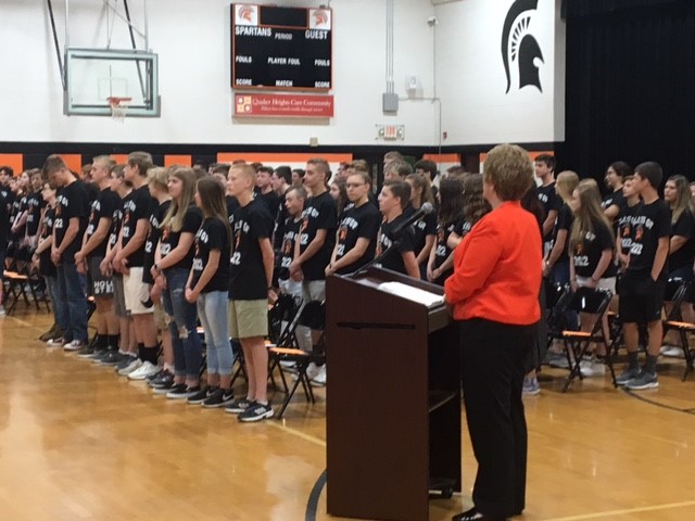 students stands during an assembly